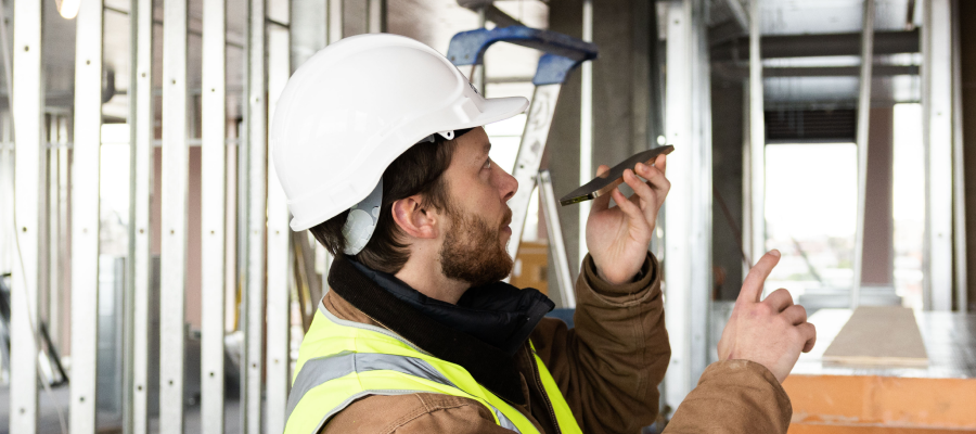 Construction worker talking into phone about a defect